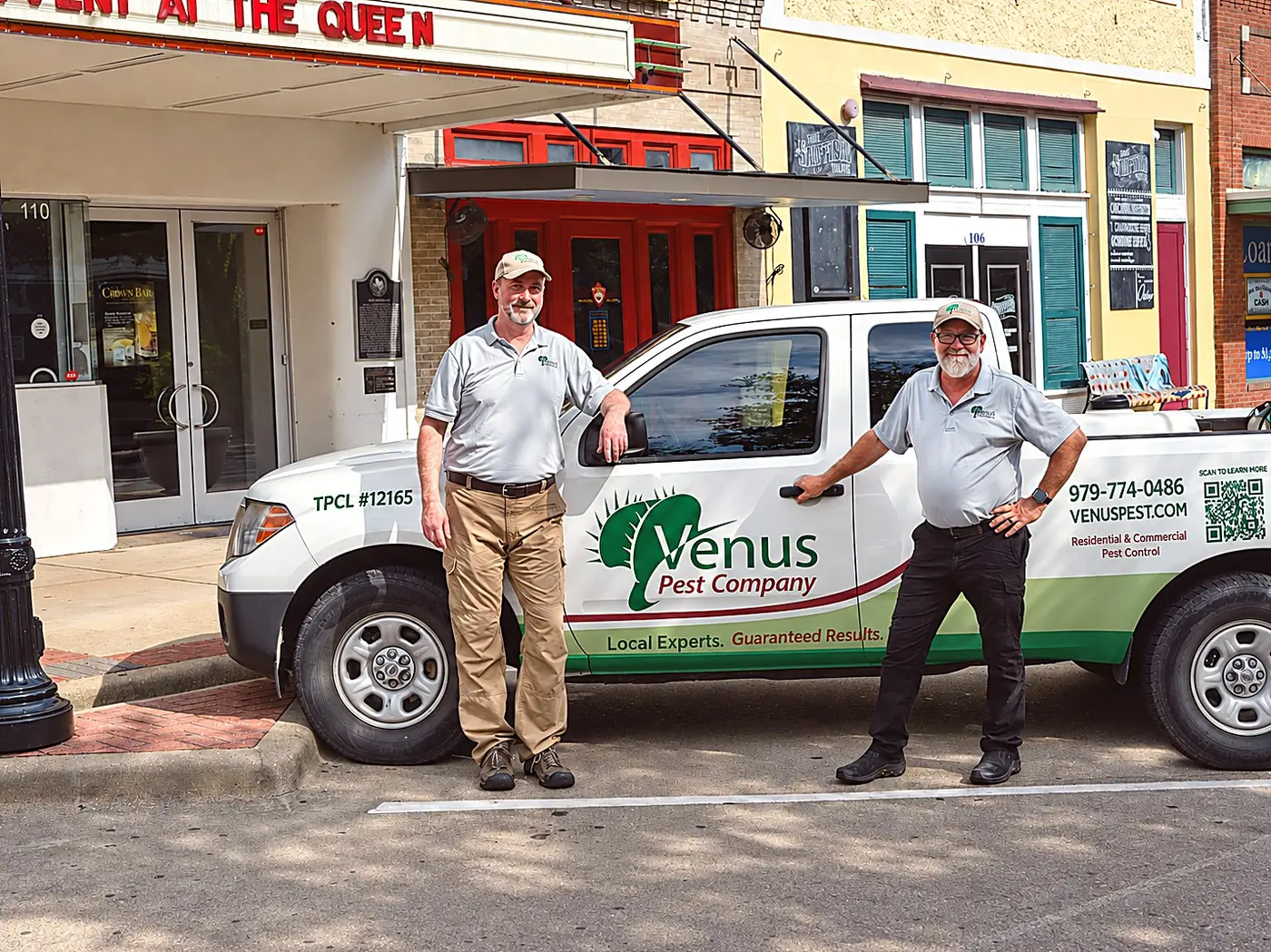 Venus Pest Company technicians with a branded truck in downtown Bryan